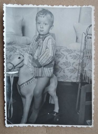 Фото мальчика на игрушечной лошадке. 1950-е. 7х11 см